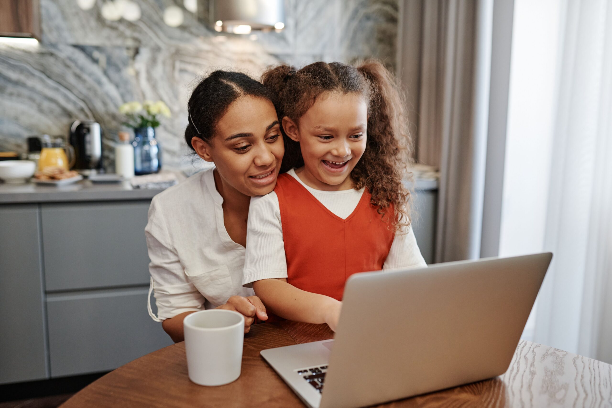Family reviewing health insurance plan options together on a laptop at their kitchen table